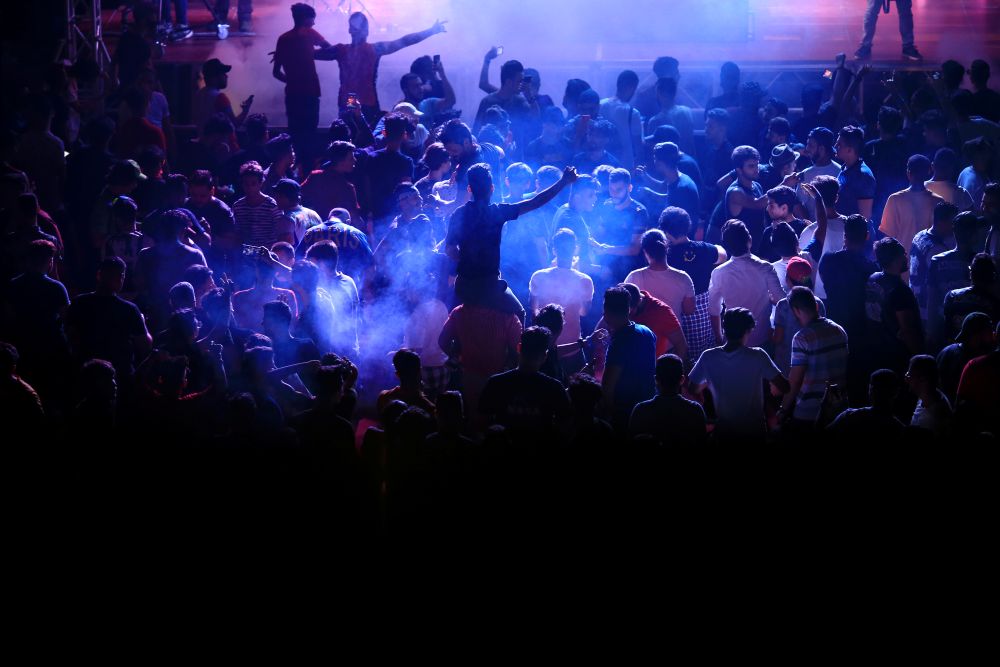 Young people dance as they attend electronic music concert with western tunes at closed Hall in Shaab Stadium for the first time in Baghdad, Iraq August 16, 2019. Picture taken August 16, 2019  REUTERS/Thaier Al-Sudani