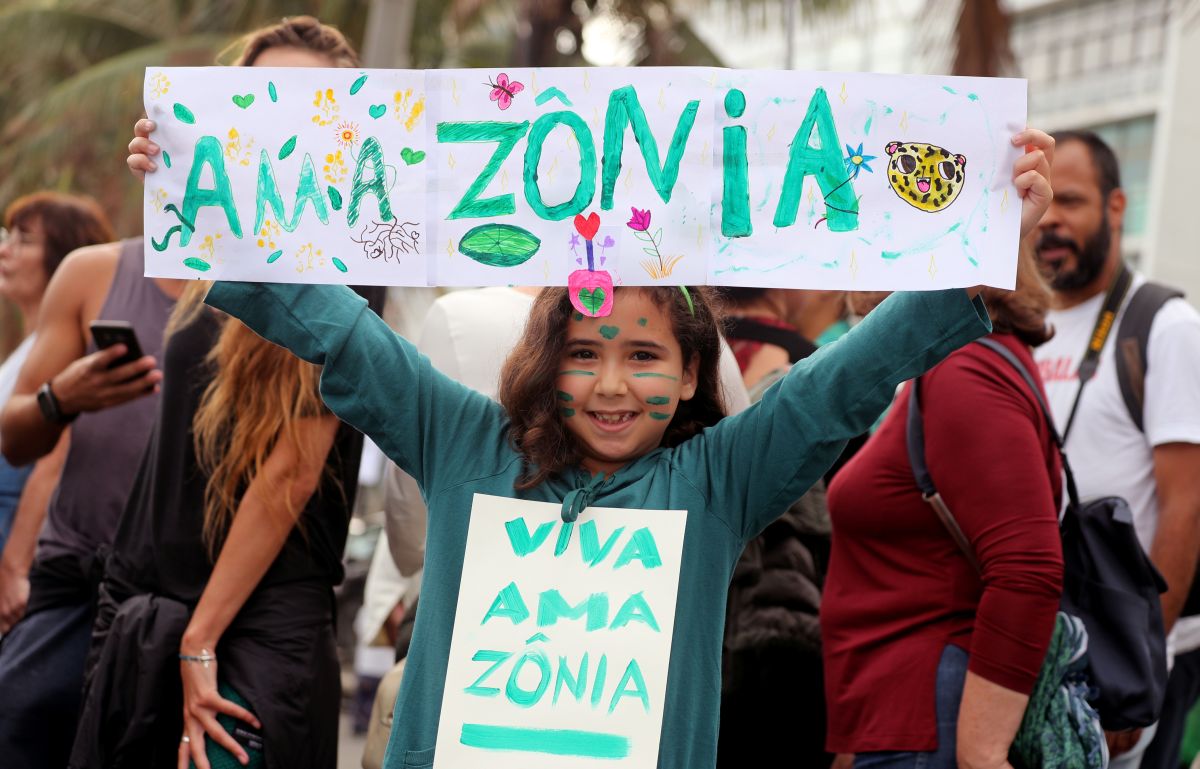 A girl holds a sign ahead of the demonstration to demand more protection for the Amazon rainforest, in Rio de Janeiro, Brazil August 25, 2019. REUTERS/Sergio Moraes
