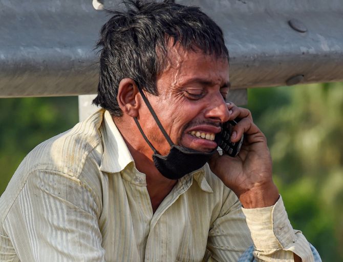 Rampukar Pandit, a migrant, weeps inconsolably while talking to a relative over his mobile phone at Nizamuddin Bridge, in New Delhi. Photograph: Atul Yadav/PTI Photo