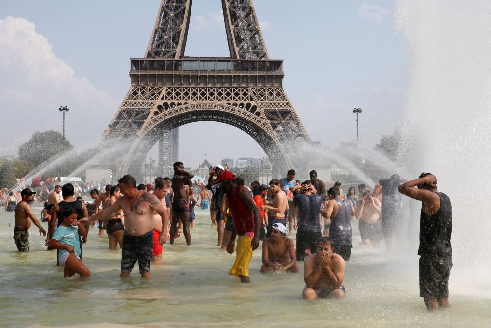 People cool off in the Trocadero fountains across from the Eiffel Tower in Paris as a new heatwave broke temperature records in France, July 25, 2019. REUTERS/Pascal Rossignol