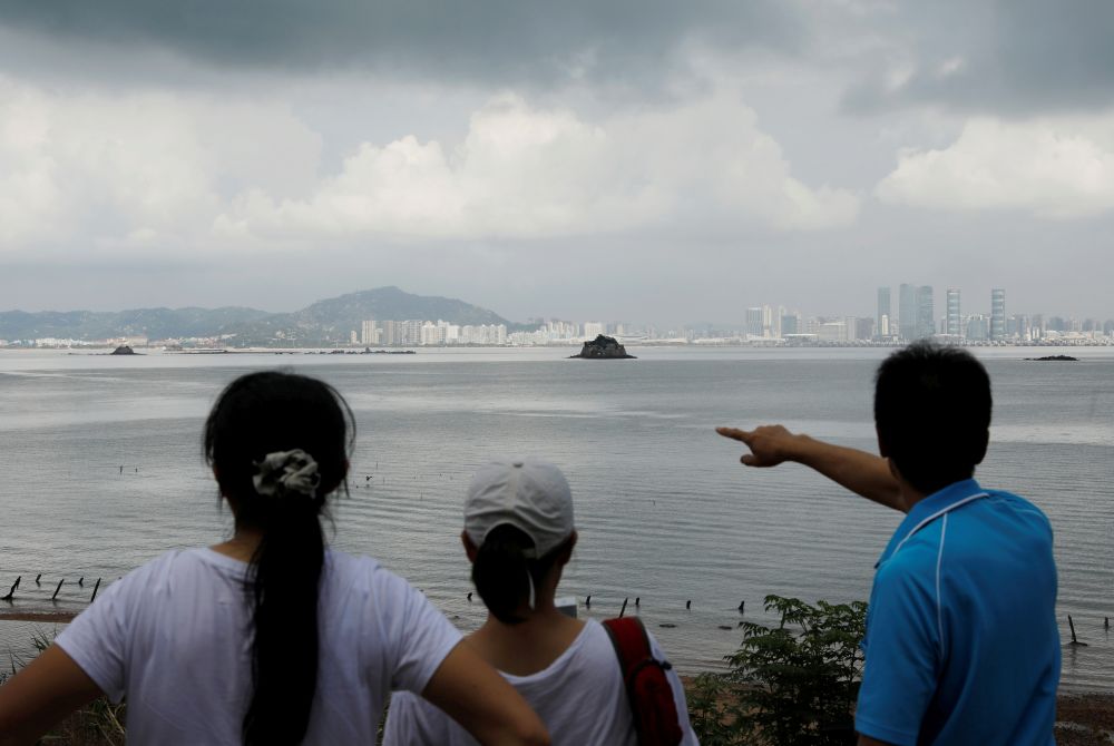  A tourist points at China's Xiamen from a former military fort, ahead of the 60th anniversary of Second Taiwan Straits Crisis against China, on Lieyu island, Kinmen county, Taiwan August 20, 2018. REUTERS/Tyrone Siu/Files