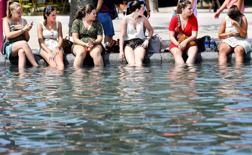 People cool off during a sunny day at a pond in front of the Rijksmuseum in Amsterdam, the Netherlands, July 25, 2019. REUTERS/Piroschka van de Wouw