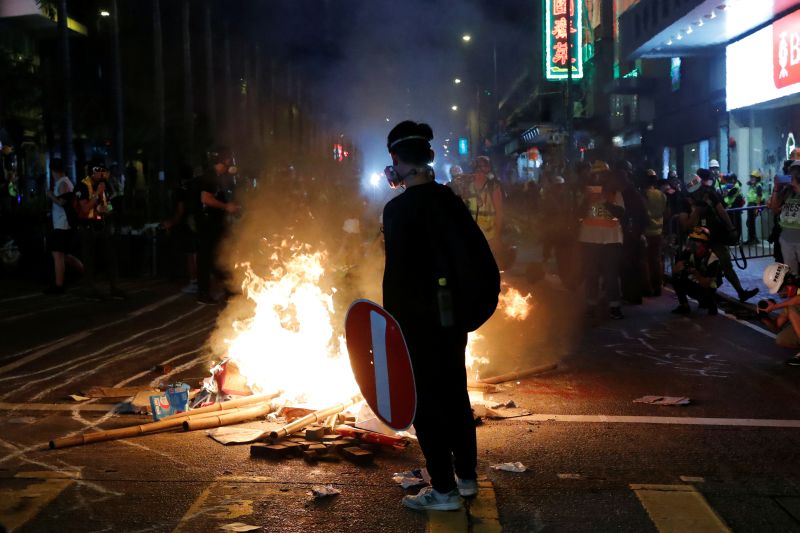 An anti-government protester stands behind a burning barrier during a demonstration, in Hong Kong, China September 29, 2019. REUTERS/Tyrone Siu/File Photo
