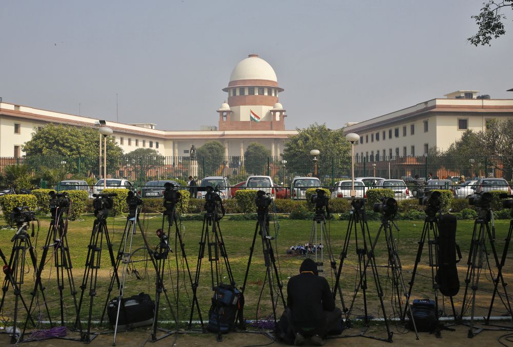 A television journalist sets his camera inside the premises of the Supreme Court in New Delhi February 18, 2014. REUTERS/Anindito Mukherjee/FILE PHOTO