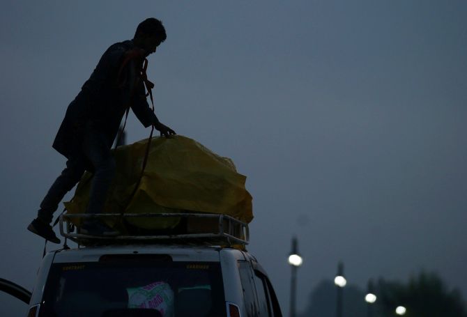 A boy loads the luggage of foreign tourists onto a passenger vehicle as they leave Srinagar August 4, 2019. REUTERS/Danish Ismail     TPX IMAGES OF THE DAY - RC1318E23900