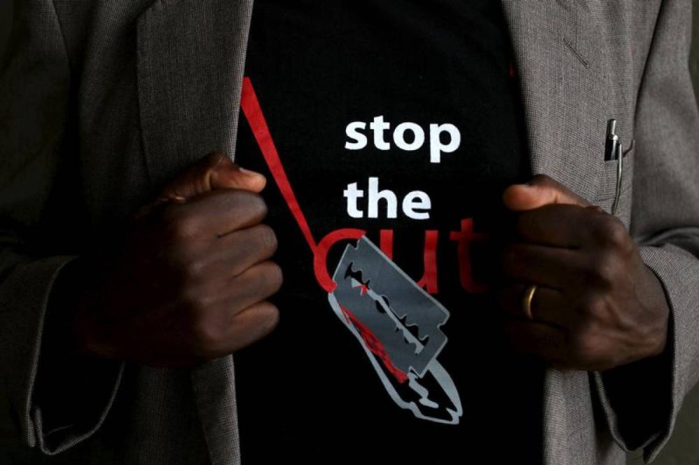 A man shows the logo of a T-shirt that reads "Stop the Cut" referring to Female Genital Mutilation (FGM) during a social event advocating against harmful practices such as FGM at the Imbirikani Girls High School in Imbirikani, Kenya, April 21, 2016. REUTE