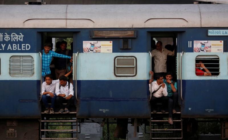 Commuters sit on the doorstep of a moving train in New Delhi, June 16, 2017. (Reuters File Photo)