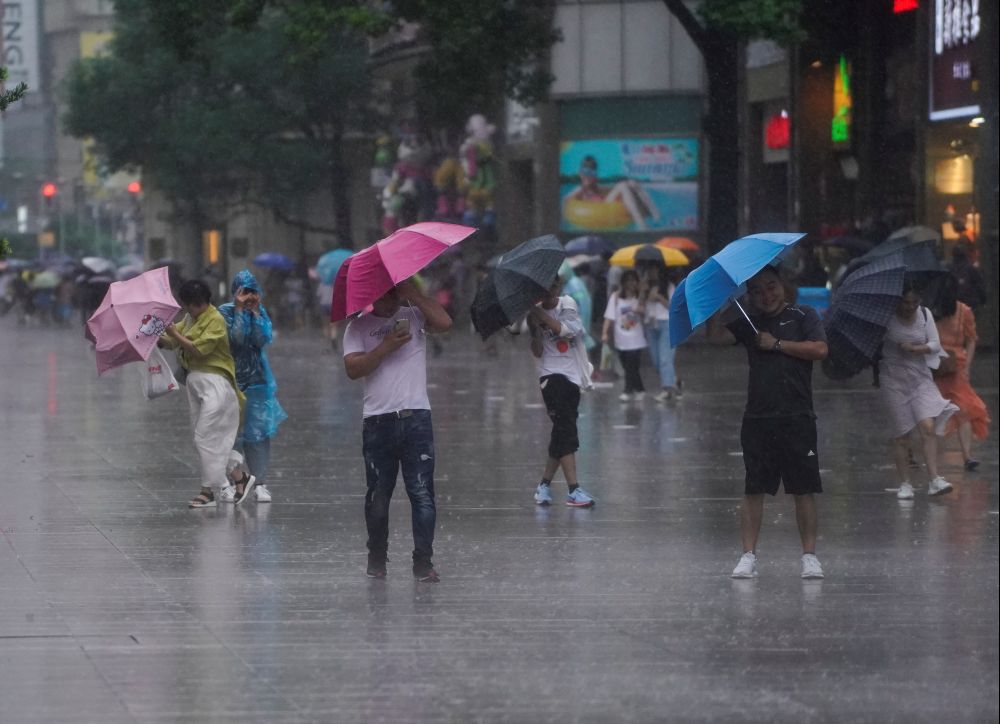 People walk in the rainstorm as typhoon Lekima approaches in Shanghai, China August 10, 2019. REUTERS/Aly Song