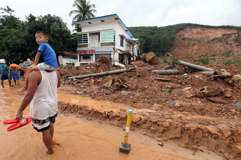 Residents walk by the site of a landdslide near Mottama, Mon State, Myanmar, August 10, 2019. REUTERS/Ann Wang