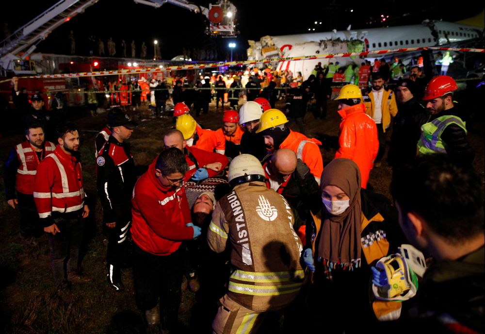 An injured person is carried away from Pegasus Airlines Boeing 737-86J plane, after it overran the runway during landing and crashed, at Istanbul's Sabiha Gokcen airport, Turkey February 5, 2020. REUTERS/Kemal Aslan