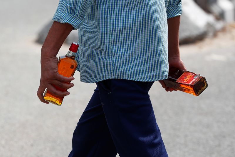 A man carries liquor bottles after buying them at a wine shop during an extended nationwide lockdown to slow the spread of the coronavirus disease (COVID-19), in New Delhi, India, May 4, 2020. REUTERS/Adnan Abidi