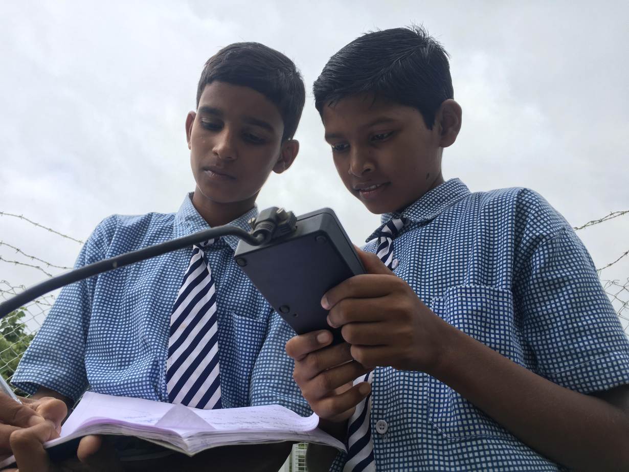 Vamshi Voggu and Gurulingam Goud, ninth grade students at the Kothapally village high school, check weather readings at the automatic weather station on their school premises in Kothapally, India, on July 31, 2019. Thomson Reuters Foundation/Roli Srivastava