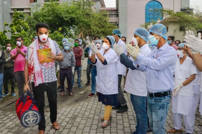 A young doctor reacts as staff of Tezpur Medical College and Hospital clap to thank him for his contribution in treating COVID-19 patients, as he leaves for isolation in a mandatory quarantine facility for seven days, in Tezpur, Assam, Monday,. (PTI Photo)
