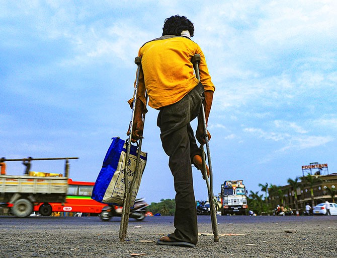 A physically challenged migrant waits for transportation in Ahmedabad. Photograph: PTI Photo