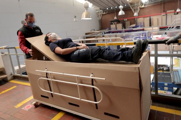 Rodolfo Gomez, a manager of the company "ABC Display" demonstrates how a hospital bed that the company manufactures is transformed into a cardboard coffin, amid the coronavirus disease (COVID-19) outbreak in Bogota, Colombia on May 21, 2020. (REUTERS Photo)