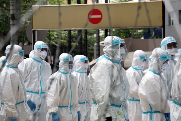 Police officers wearing protective suits gather outside an apartment under enhanced lockdown to pick up illegal immigrants, during the movement control order due to the outbreak of the coronavirus disease (COVID-19), in Kuala Lumpur, Malaysia, May 1, 2020