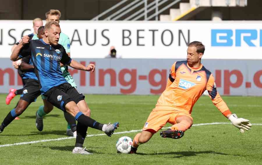 Hoffenheim's Oliver Baumann in action with Paderborn's Ben Zolinski, as play resumes behind closed doors following the outbreak of COVID-19. (REUTERS)