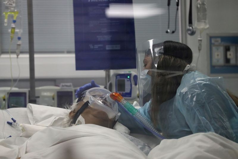 A relative touches 76-year-old Jaime, who is infected with the coronavirus disease (COVID-19), during a final goodbye inside an Intensive Care Unit of the University of Chile's clinical hospital in Santiago, Chile on June 18, 2020. (REUTERS Photo)