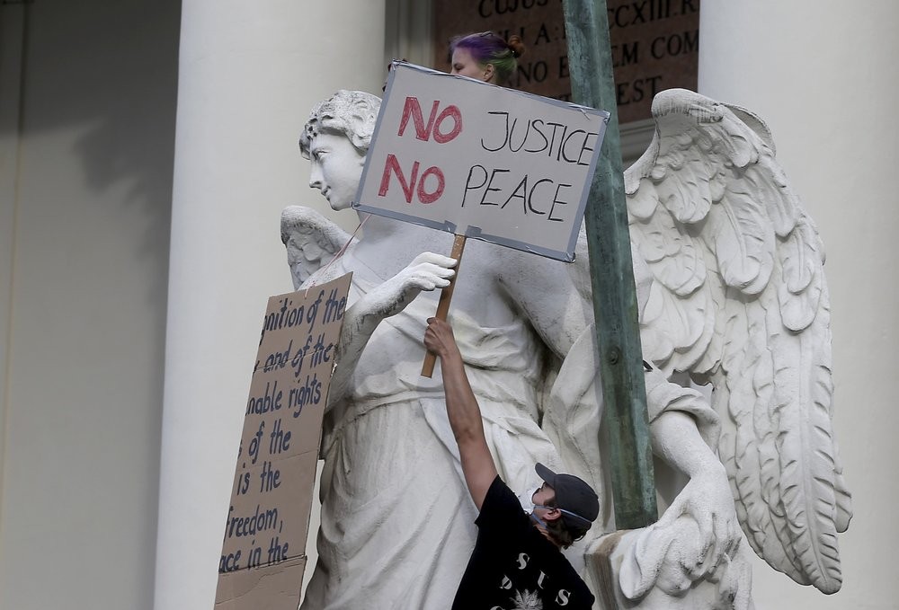 Demonstrators gather in Vienna, Austria, Thursday, June 4, 2020, to protest against the recent killing of George Floyd by police officers in Minneapolis, USA, that has led to protests in many countries and across the US. A US police officer has been charged with the death of George Floyd. (AP Photo/Ronald Zak)