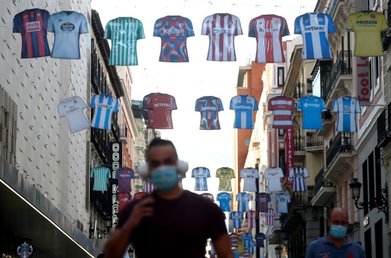 A man walks under decorations depicting shirts of Spanish First Division soccer clubs days before resuming the competition amid the coronavirus disease (COVID-19) outbreak, in Madrid, Spain on June 8, 2020. (REUTERS Photo)