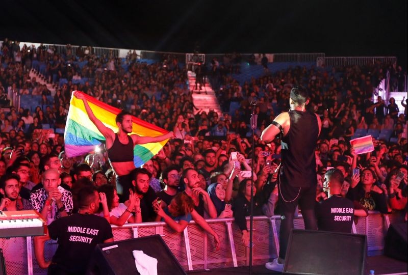 A fan of Lebanese alternative rock band Mashrou' Leila holds a rainbow flag during their concert at the Ehdeniyat International Festival in Ehden town, Lebanon. (REUTERS File Photo)