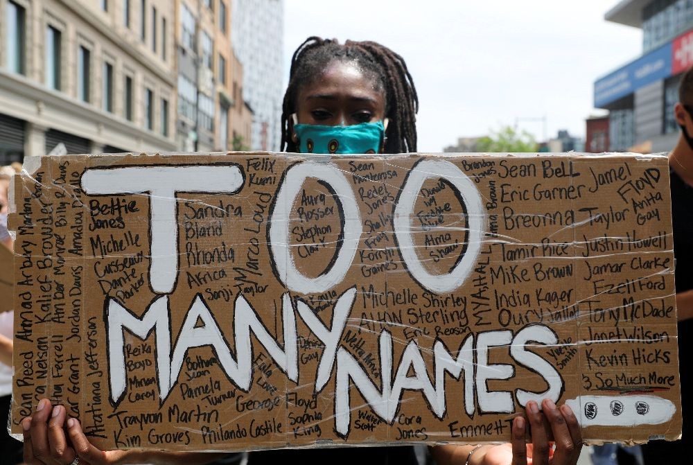 A demonstrator holds a placard during a protest against racial inequality in the aftermath of the death in Minneapolis police custody of George Floyd, in Brooklyn, New York, U.S. June 6, 2020. REUTERS/Jeenah Moon