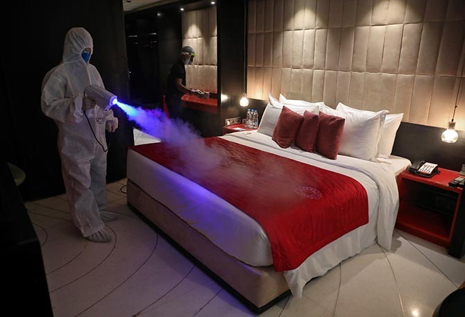 A worker wearing protective gear sanitises a room at a hotel in Kolkata. Photograph: Rupak De Chowdhuri/Reuters