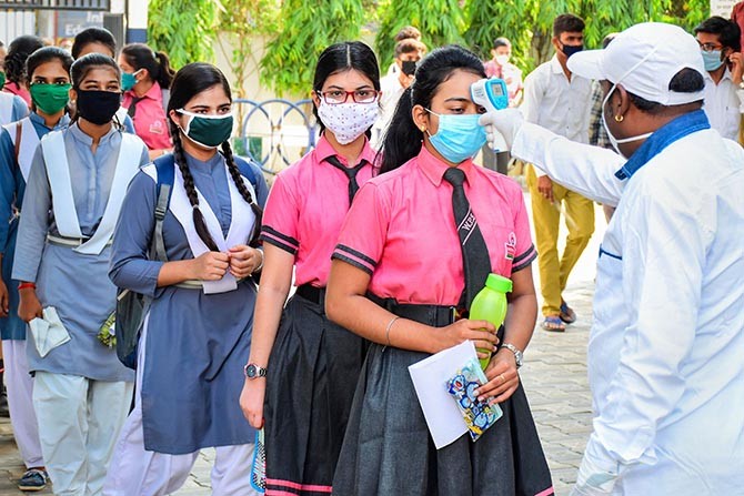 Students wearing protective masks undergo thermal screening before appearing in the 12th class examinations of Madhya Pradesh Board of Secondary Education, during the fifth phase of ongoing COVID-19 lockdown, in Jabalpur. Photograph: PTI Photo