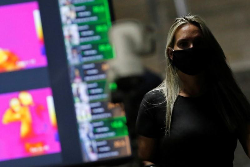 A woman wearing a protective face mask is seen next a thermal camera used to detect high body temperatures at the central bus station and Metro's Central station, amid the coronavirus disease (COVID-19) outbreak, in Brasilia, Brazil, June 2, 2020. REUTERS/Adriano Machado