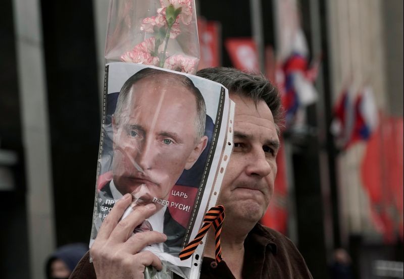 A man demonstrates a portrait of Russian President Vladimir Putin during the celebrations of Victory Day, which marks the anniversary of the victory over Nazi Germany in World War Two, in Moscow, Russia on May 9, 2020. The poster reads: "Tsar of All Rus' ". (REUTERS File Photo)