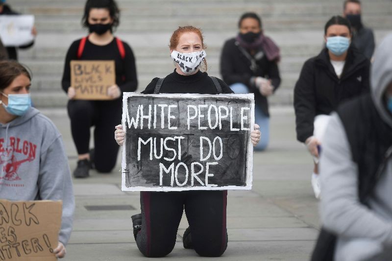 A woman wearing a protective face mask kneels as she holds a sign during a Black Lives Matter protest in Trafalgar Square in London, following the death of George Floyd who died in police custody in Minneapolis. London, Britain, June 5, 2020. (Photo by Toby Melville/Reuters)