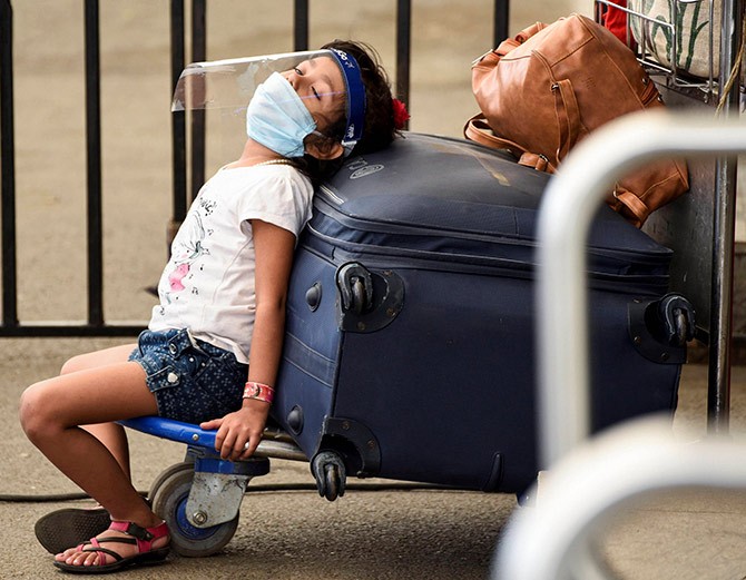 A girl takes a nap on a luggage trolley at the Lokpriya Gopinath Bordoloi airport in Guwahati. Photograph: PTI Photo