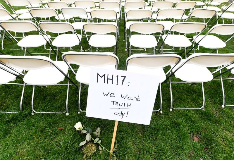 A protest sign stands in front of a row of chairs as family members of victims of the MH17 crash lined up empty chairs for each seat on the plane during a protest outside the Russian Embassy in The Hague, Netherlands on March 8, 2020.  (REUTERS File Photo)