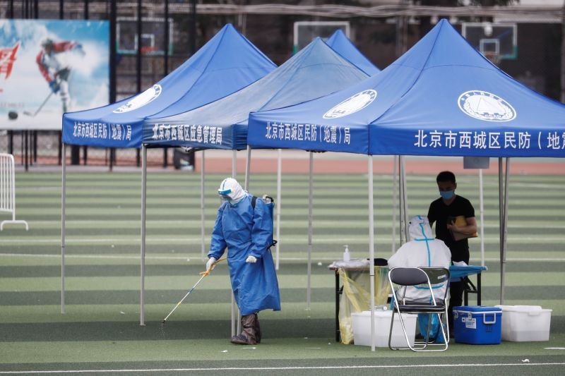 A man in personal protection gear sprays disinfectant at a testing site at the Guangan Sport Center after an unexpected spike of cases of the coronavirus disease (COVID-19) in Beijing, China on June 15, 2020.   (REUTERS Photo)