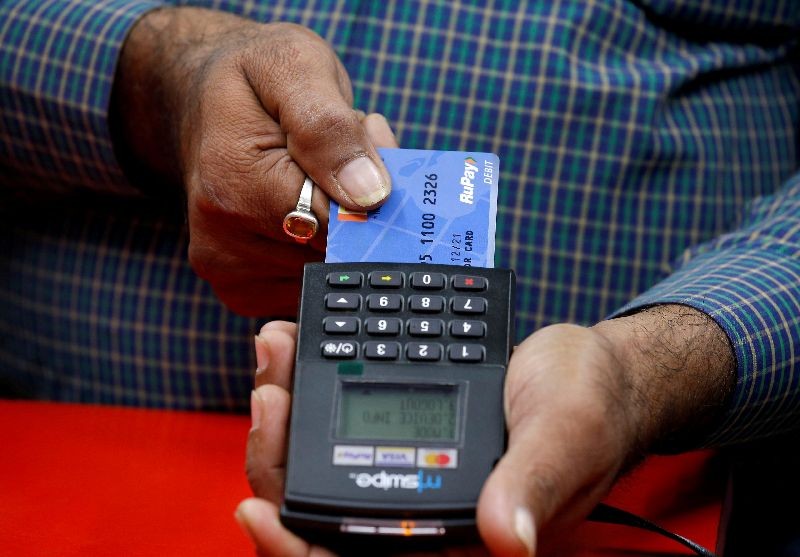 A shopkeeper swipes a customer's debit card with the logo of RuPay at an electronics goods store in Kolkata, October 31, 2018.  REUTERS/Rupak De Chowdhuri/File Photo