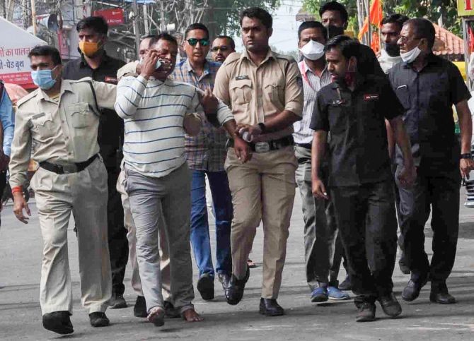 Gangster Vikas Dubey, the main accused in killing of eight policemen in the Kanpur encounter, being apprehended by police personnel after a nearly week-long manhunt, in Ujjain, Thursday. Photograph: PTI Photo
