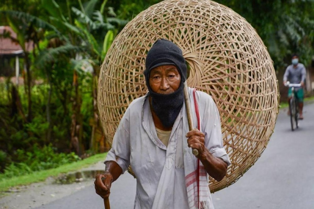 An elderly man walks to a market to sell bamboo baskets during ongoing COVID-19 lockdown at Baganpara in Baksa district of Assam. (Photo | PTI)