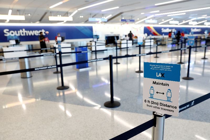 Social distancing sign is displayed at a check-in area for Southwest Airlines Co. at Los Angeles International Airport (LAX) on an unusually empty Memorial Day weekend during the outbreak of the coronavirus disease (COVID-19) in Los Angeles, California, U.S., May 23, 2020. REUTERS/Patrick T. Fallon/File Photo