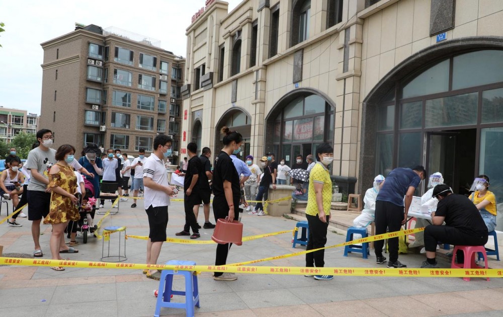 Residents wearing face masks line up to receive nucleic acid tests after new cases of coronavirus disease (COVID-19) were confirmed in Dalian, Liaoning province, China July 26, 2020. cnsphoto via REUTERS