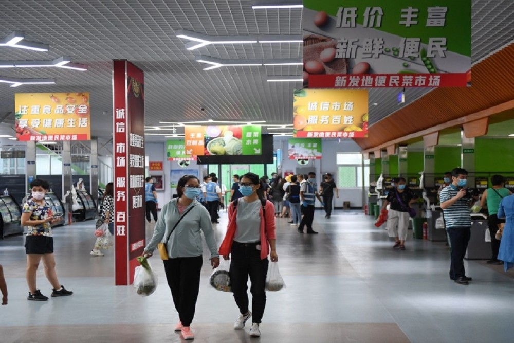 Customers shop in a vegetable market set up outside the Xinfadi wholesale market in Beijing, China (Photo: IANS)