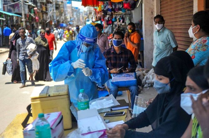 A medic wearing PPE kit while collecting samples for COVID-19 tests, in Bengaluru, on Tuesday. Photograph: PTI Photo