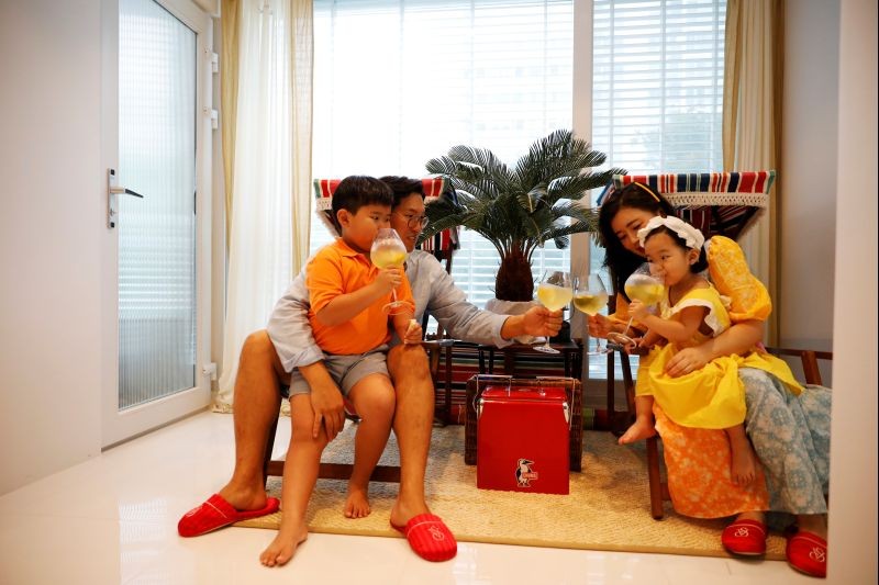 Yoon Seok-min and Kim Hyo-jung drink a beverage with their children at their home in Yongin, South Korea, August 13, 2020. Picture taken August 13, 2020.    REUTERS/Kim Hong-Ji