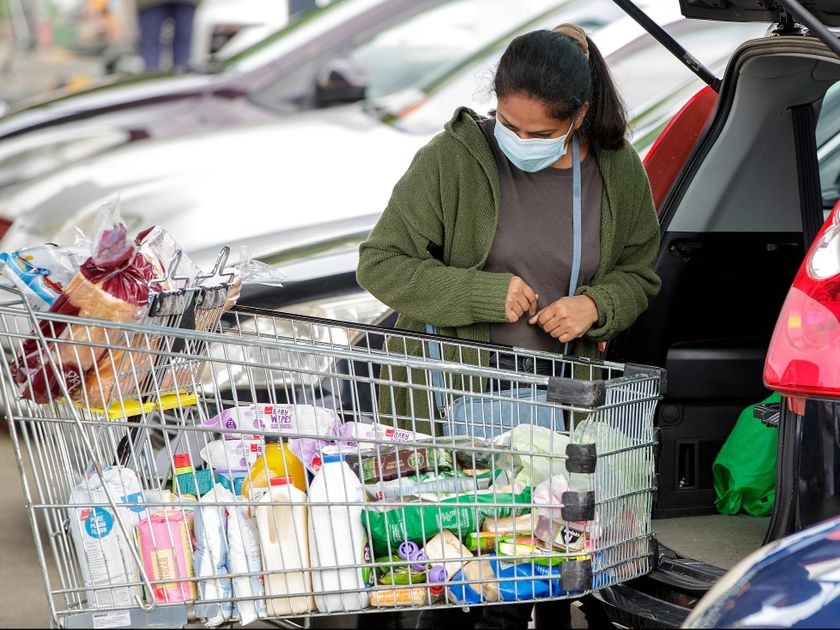 A face mask-clad shopper packs groceries in the suburb of Takapuna in Auckland, New Zealand on Aug. 12, 2020. DAVID ROWLAND / AFP via Getty Images
