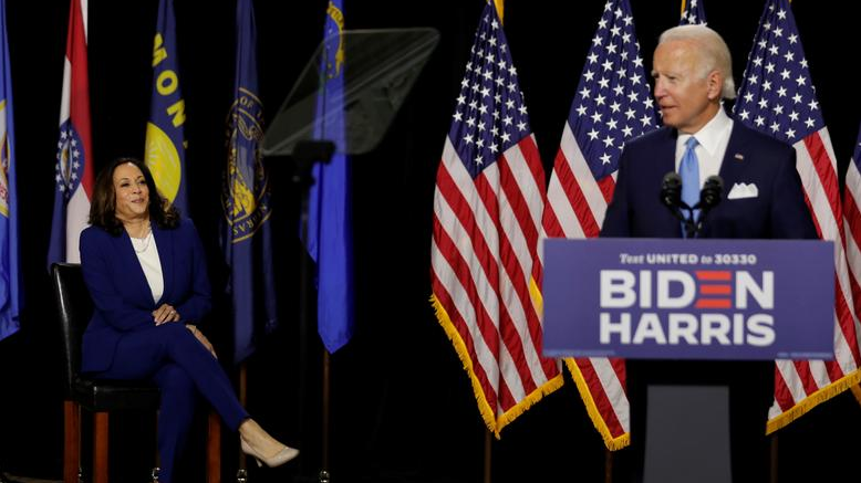 Joe Biden (R) speaks at a campaign event as Kamala Harris listens. /Reuters