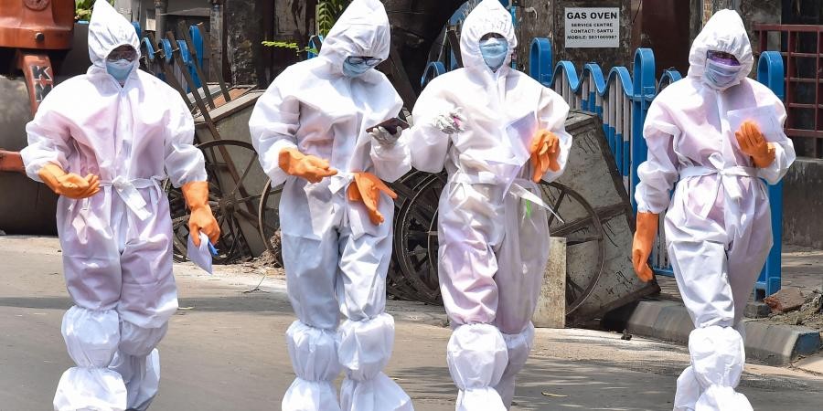 Health workers wearing protective suits walk on a street during their door-to-door survey to detect COVID-19 positive cases amid a nationwide lockdown to curb the spread of coronavirus in Kolkata on April 20 2020. (PTI File Photo)