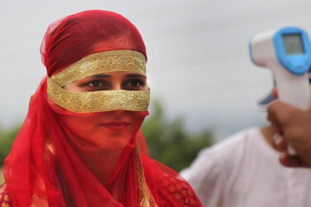 A man checks the temperature of a woman as a precaution against the coronavirus. (Photo | AP)
