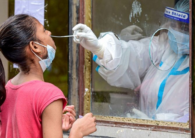 A medic collects a nasal sample from a girl for COVID-19 test at a centre in New Delhi, on Friday. Photograph: Kamal Kishore/PTI Photo