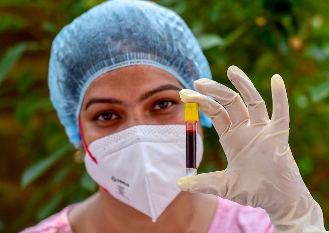A health worker holds a blood sample, collected for COVID-19 antibody test in New Delhi. Photograph: Kamal Kishore/PTI Photo