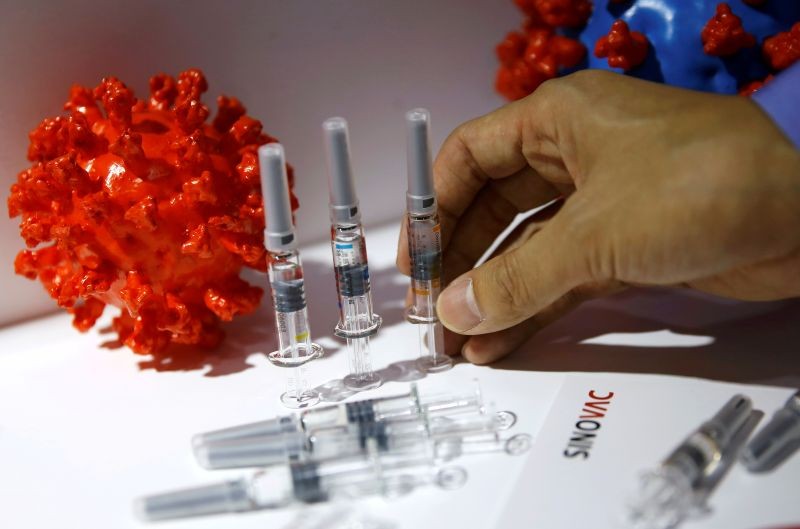 A staff member places a coronavirus vaccine candidate from Sinovac Biotech Ltd at its booth for display during the 2020 China International Fair for Trade in Services (CIFTIS), following the COVID-19 outbreak, in Beijing, China September 5, 2020. REUTERS/Tingshu Wang/File Photo