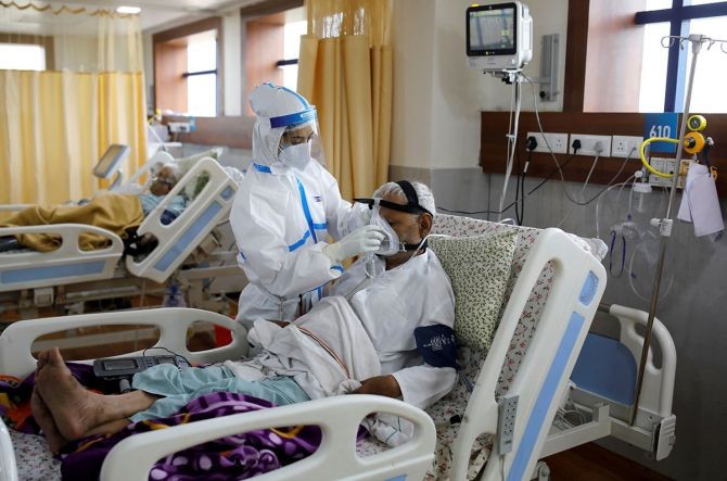 A medical worker takes care of a patient suffering from COVID-19 at a hospital in Noida. Photograph: Adnan Abidi/Reuters